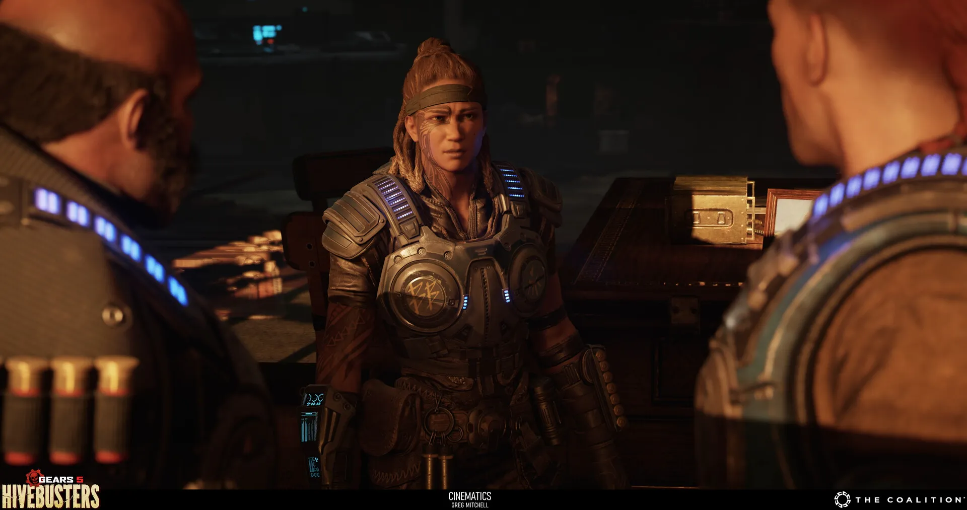 Armoured woman stands between two figures in a warmly lit room